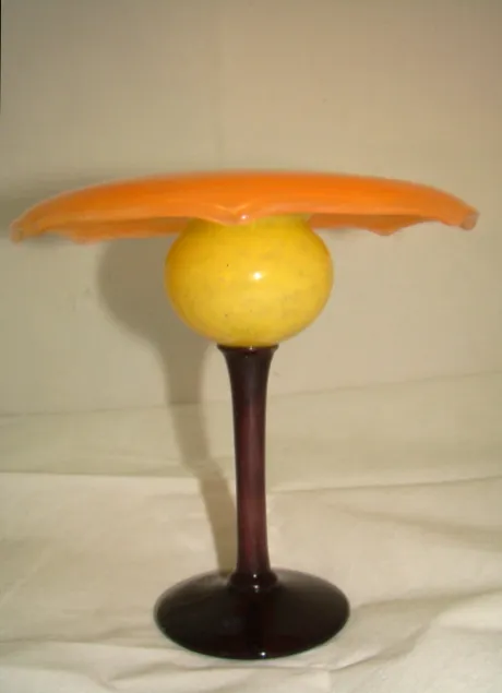 Vidrio antiguo con firma amarilla y base negra.