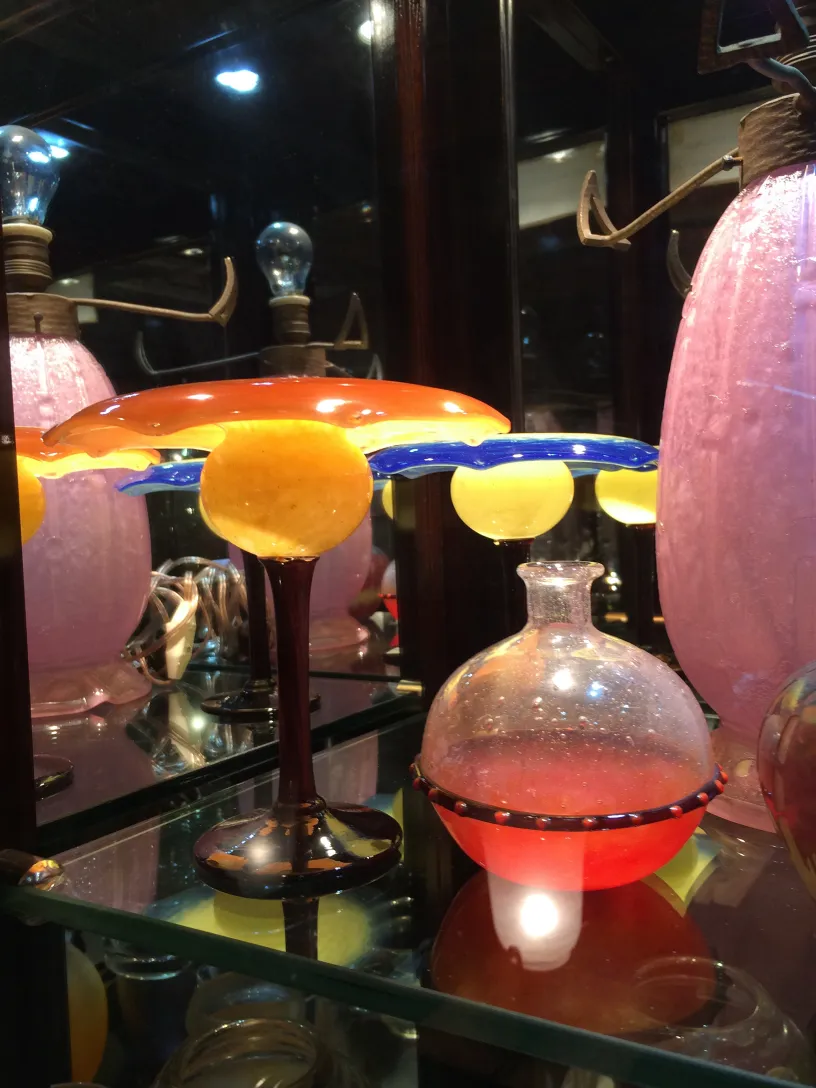 Signed glass Schneider on display, bright colors and creative shape in an antique setting.