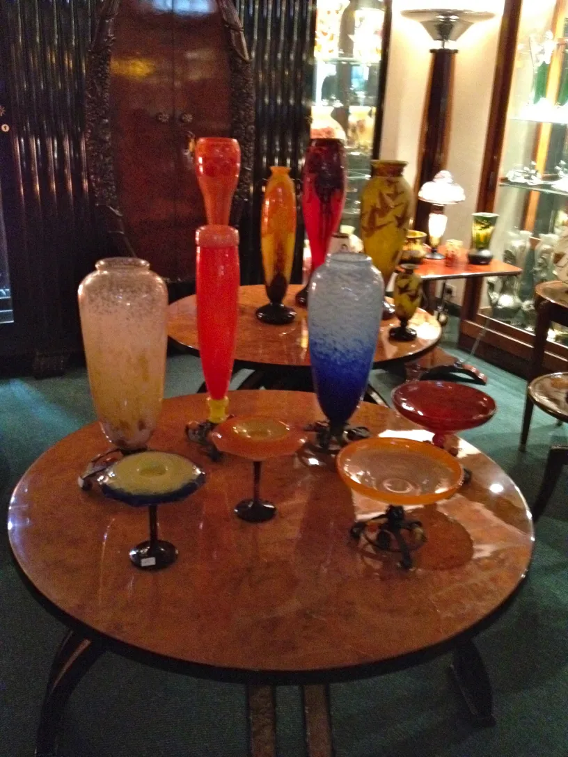 Anordnung unterschiedlicher eleganter Glasvasen und Teller auf einem Tisch