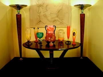 une collection d'antiquités sur une table élégante avec du verre signé