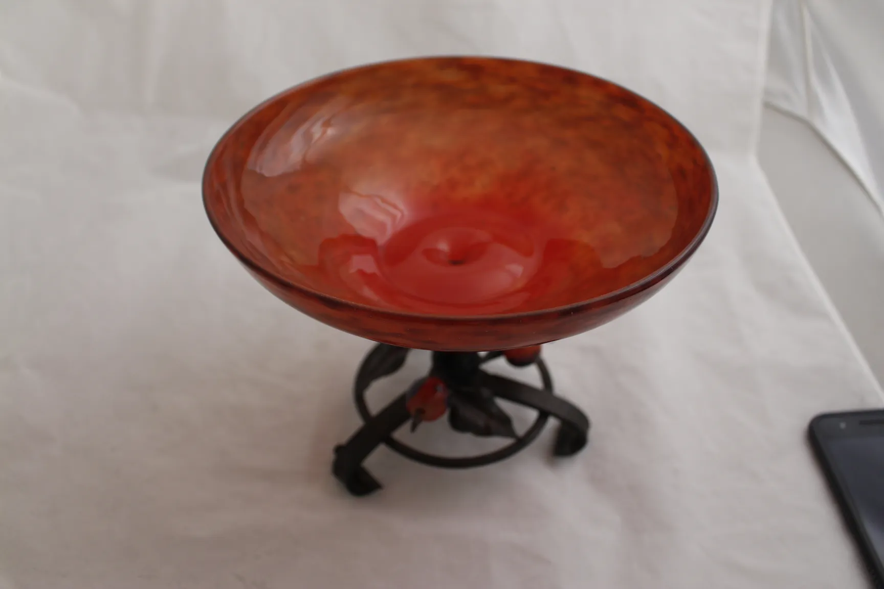 red signed glass on black metal stand