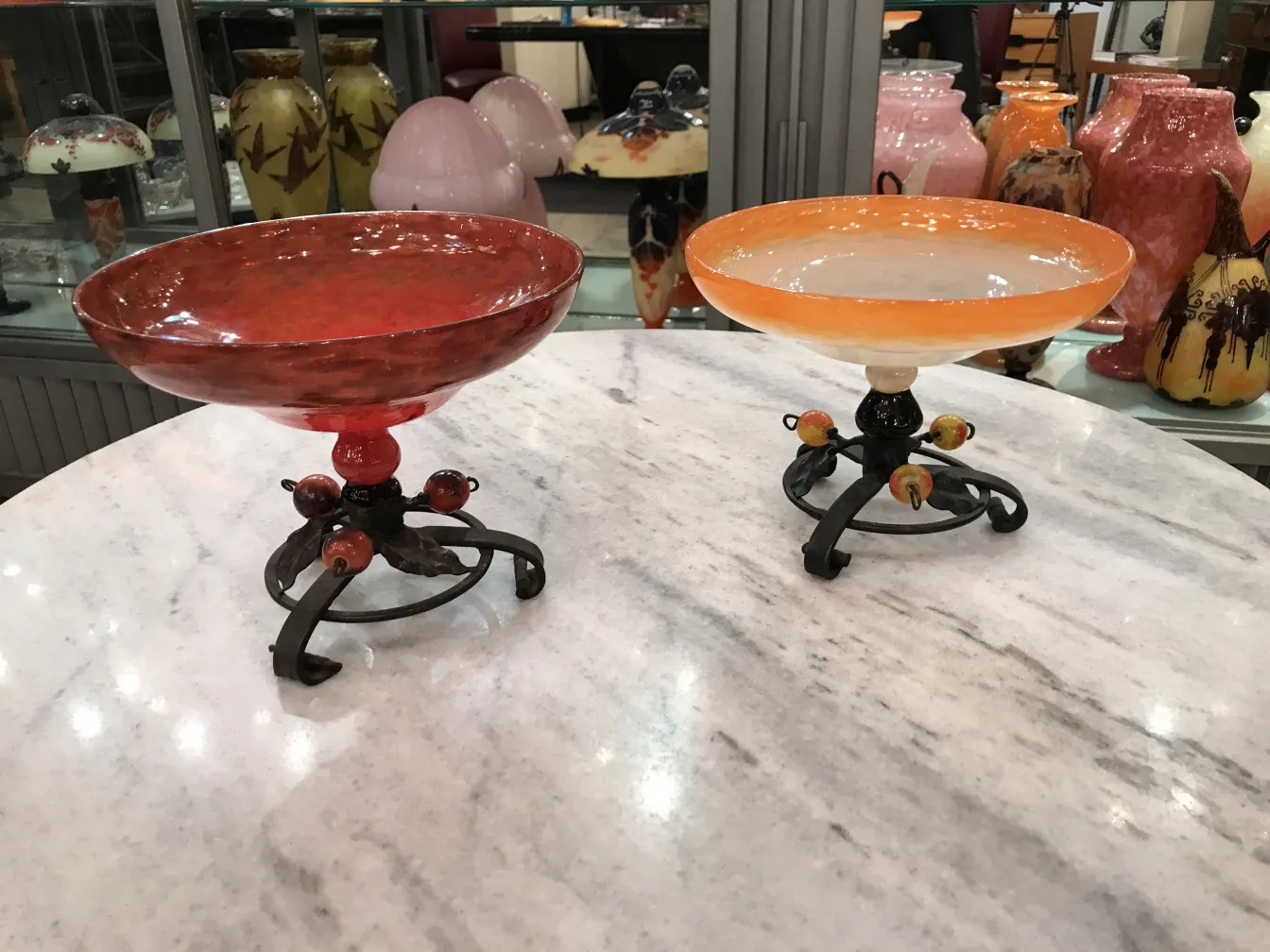 Duo d'antiquités, verre signé Schneider en rouge et orange, sur des pieds décoratifs.
