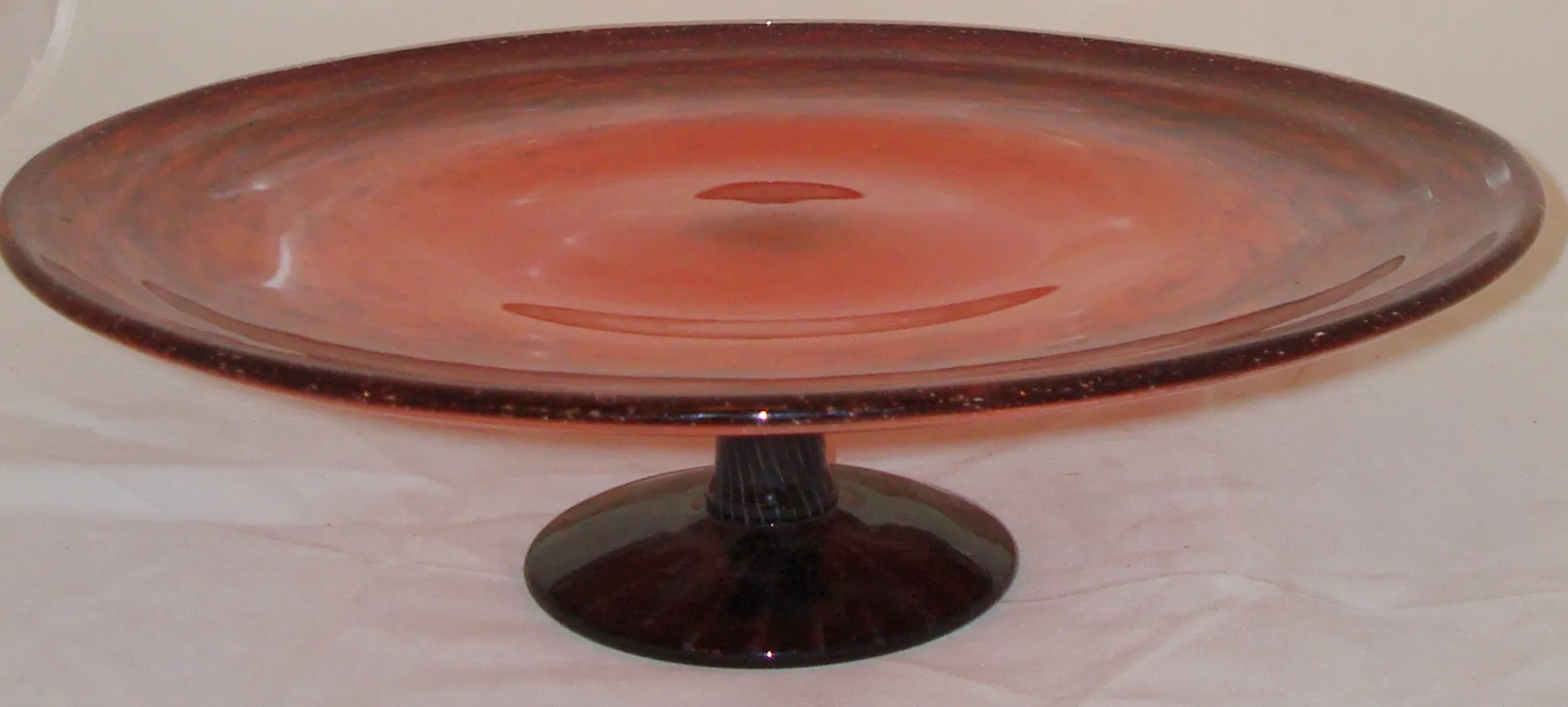 طبق زجاجي موقّع بألوان وردية وسوداء، خلفية فاتحة