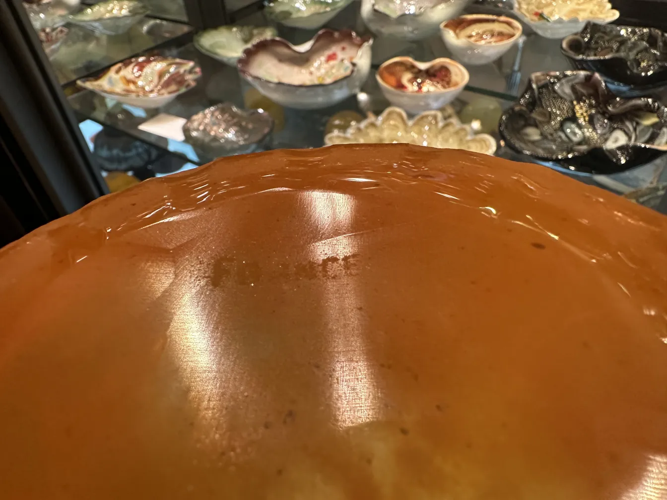 Vidro antigo com assinatura Schneider, fundo colorido.