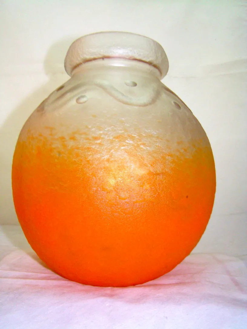 Verre signé de forme ronde en couleur orange et transparente.