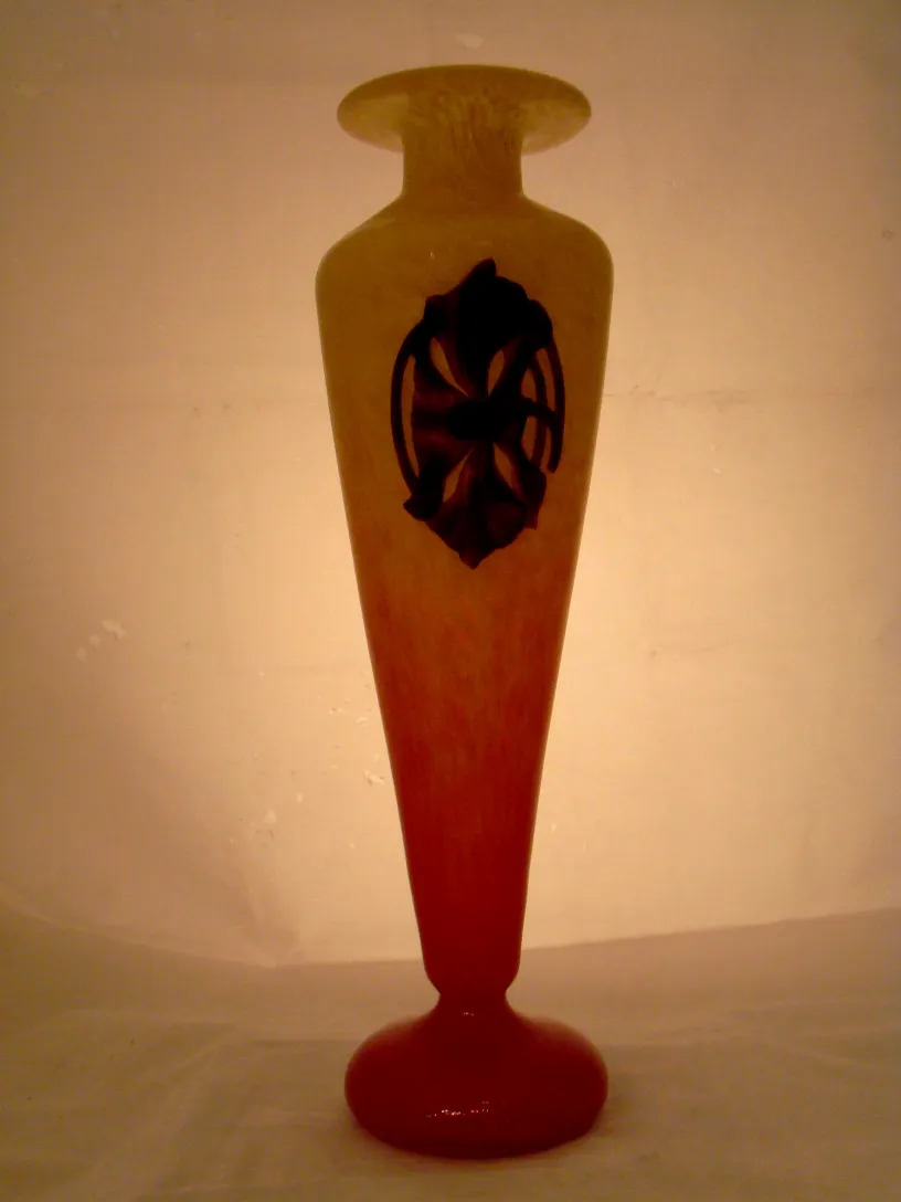 Vaso in vetro antico con design distintivo e sfondo illuminato.