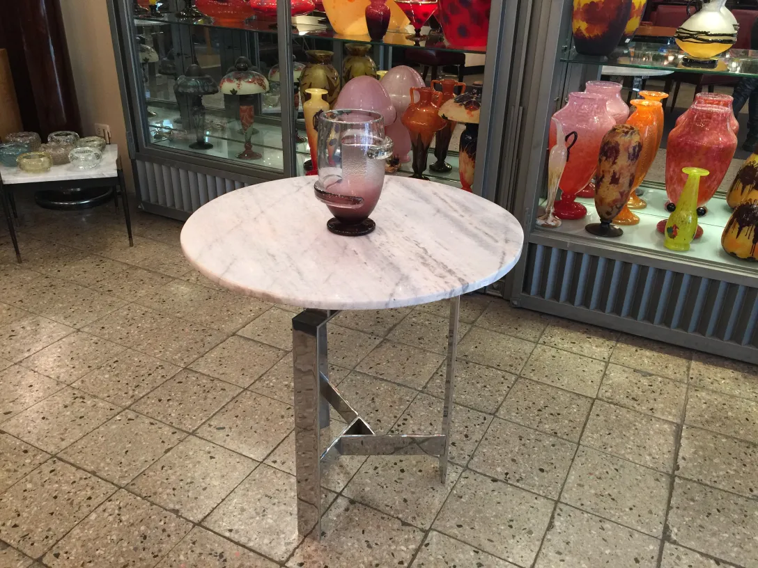 Vidrio firmado Schneider en una mesa rodeado de antigüedades