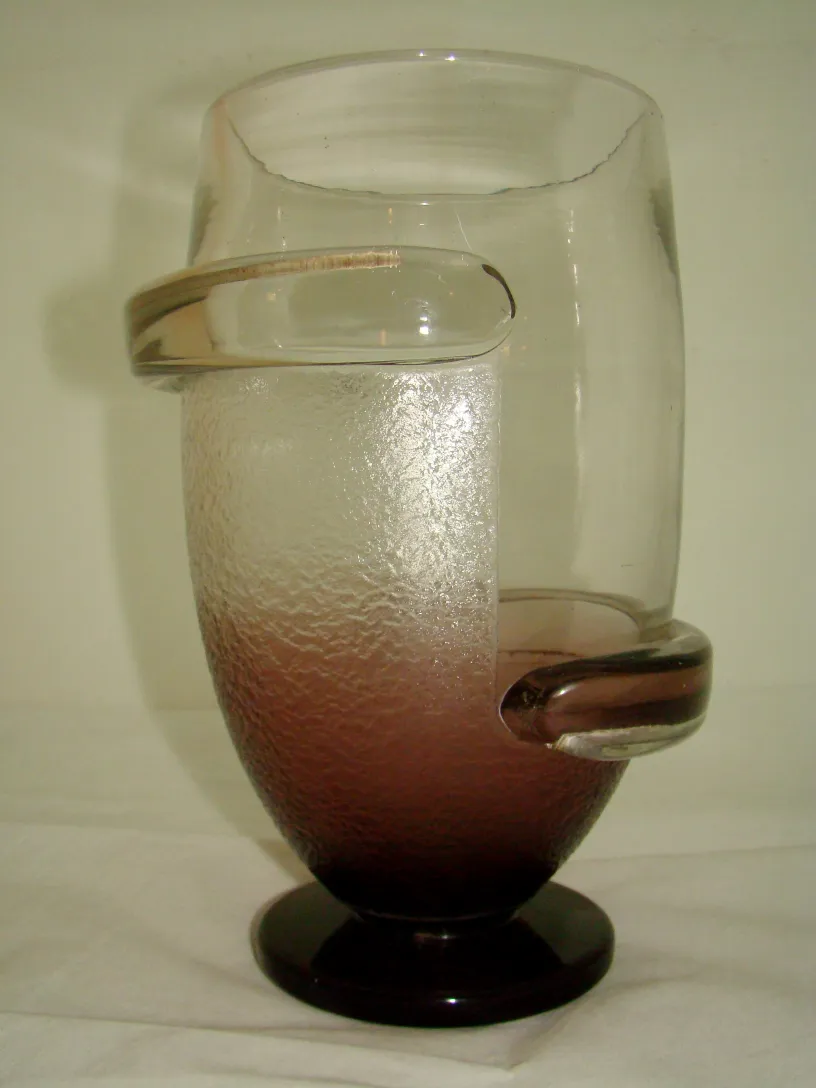 Antique signed glass by Schneider, featuring a unique design and gradient color in a neutral setting.