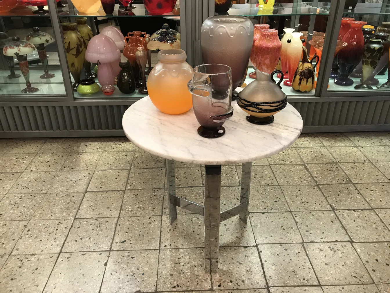 Vidrio firmado Schneider antiguo con diseños sutiles y colores variados, en un ambiente de antigüedades.