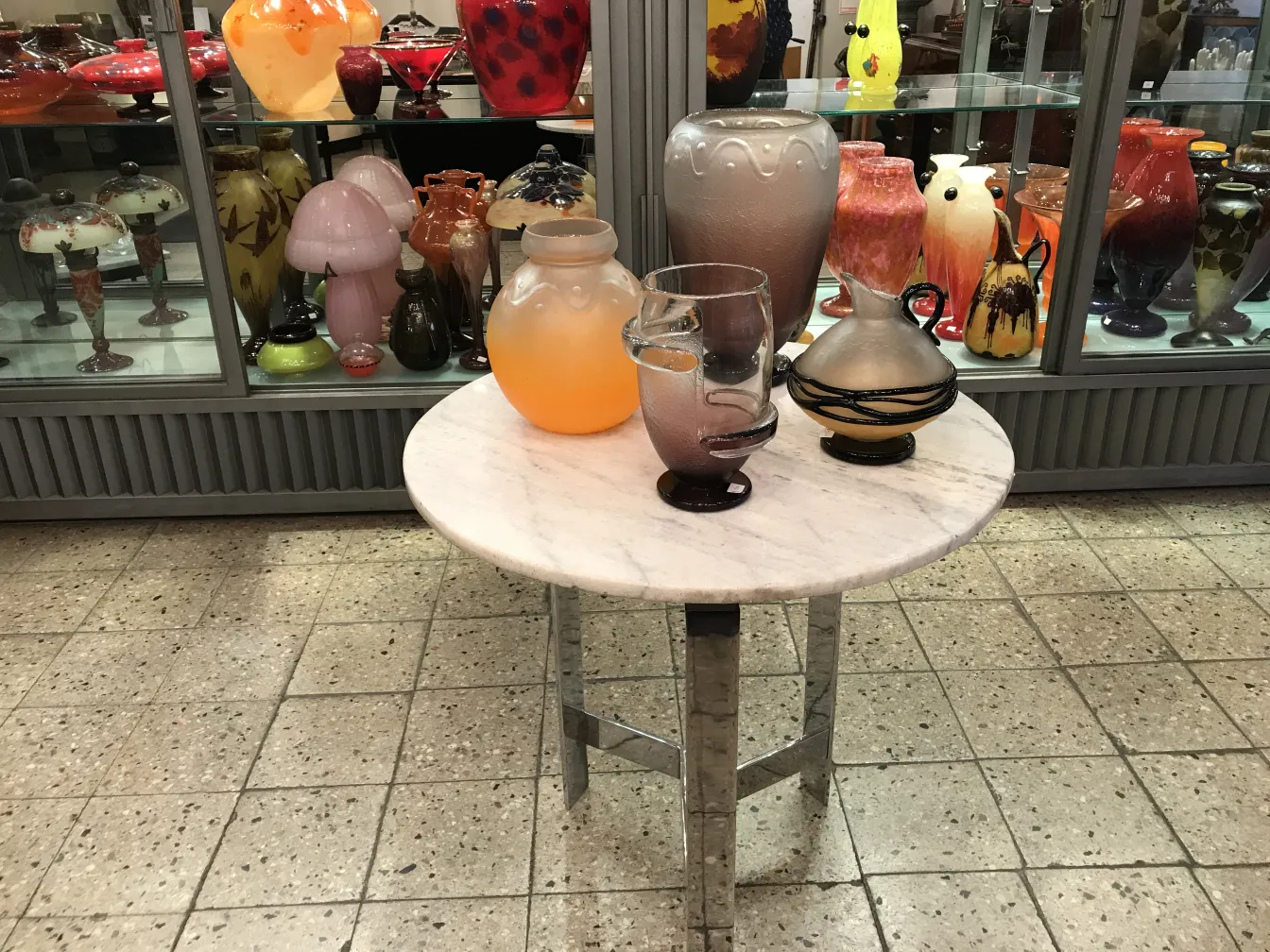 アンティークサイン入りグラス（シュナイダー）、背景に様々なカラフルな花瓶がある。