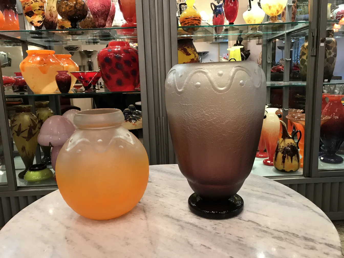 Vaso di vetro firmato con forme ondulate, tra antichità colorate.