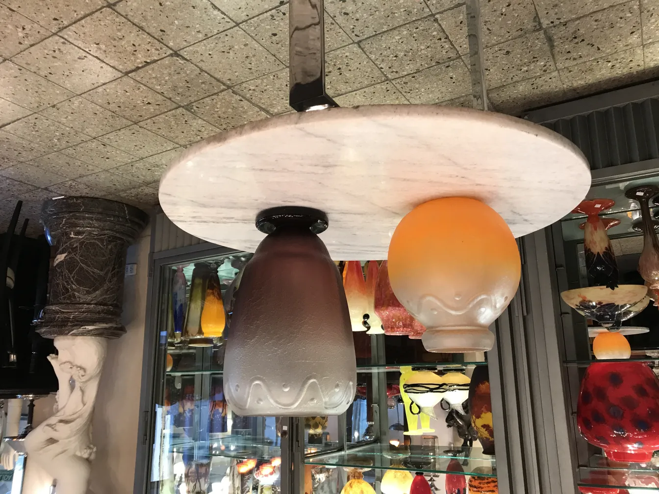 Luminária antiga com vidro assinado de Schneider, fundo de antiguidades.