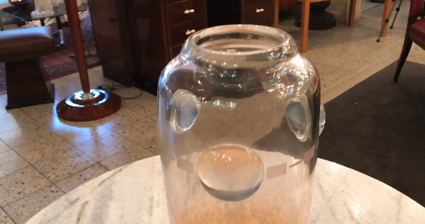 Antique signed glass by Schneider with visible details inside, displayed on a table.