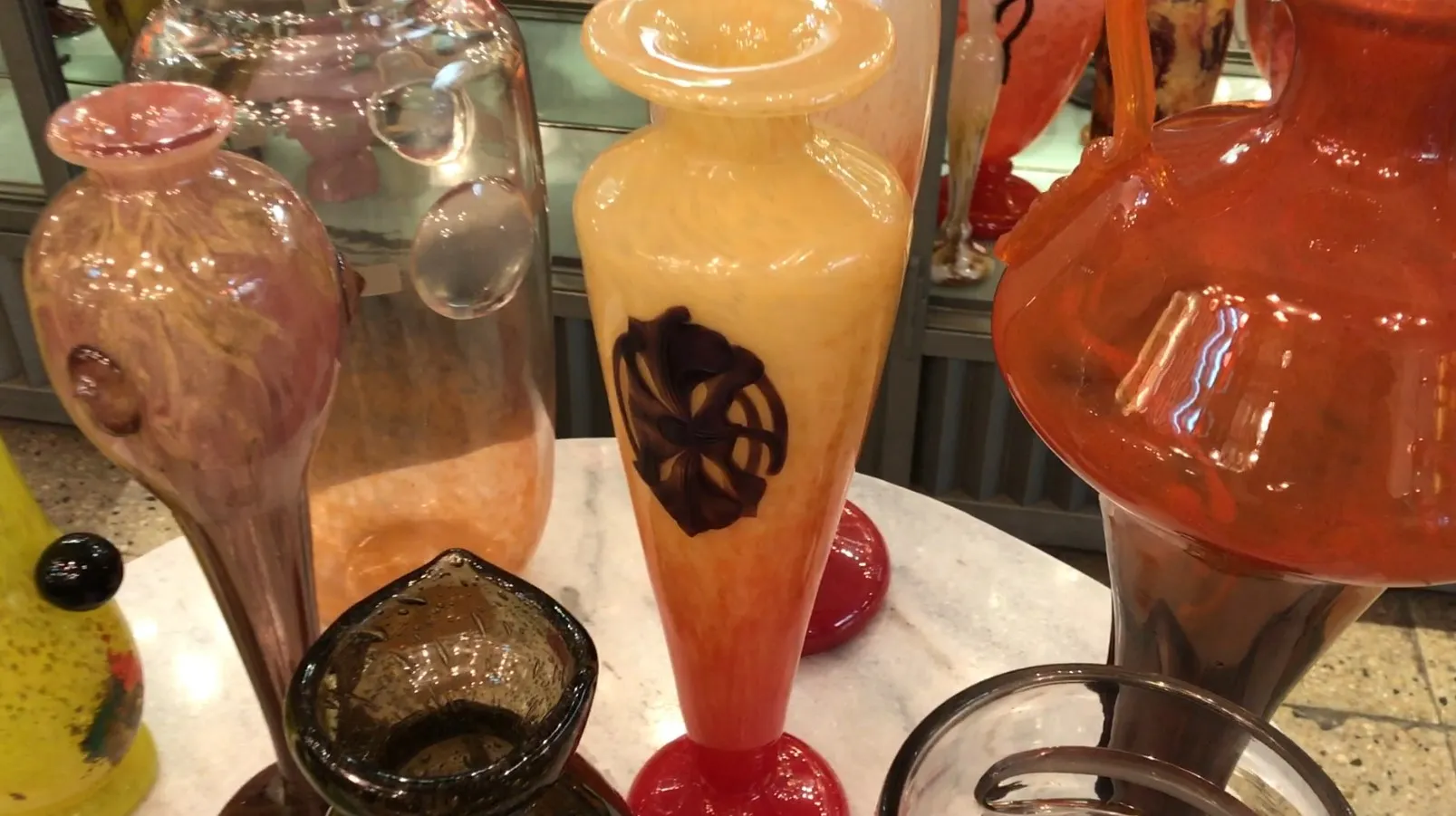 Antique glass vases with floral design in the background.