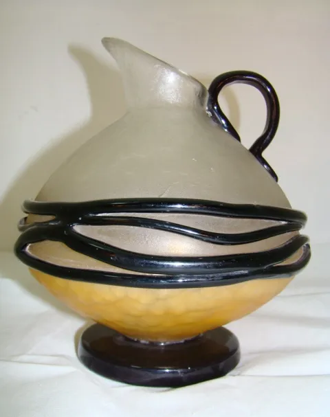 Caraffa in vetro antico firmata con dettagli fluidi, stile classico.