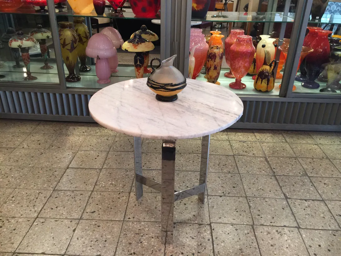 Antikes signiertes Glas mit künstlerischen Mustern im Hintergrund.