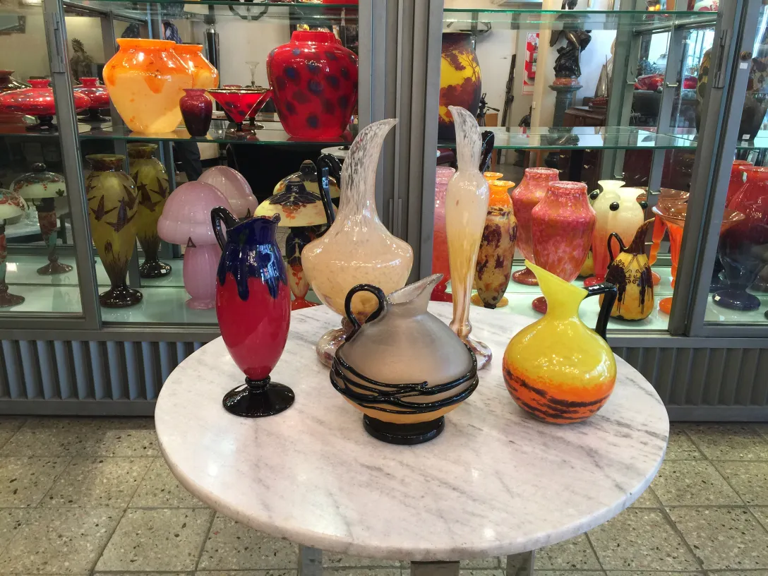 Signed glass by Schneider, decorative antique with vibrant colors and varied shapes in a display setting.