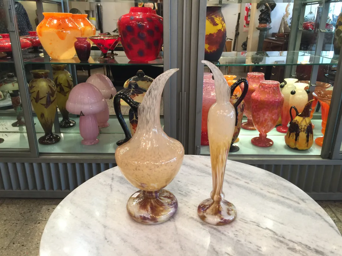 Two antique jars of signed glass by Schneider, elegant and colorful, in an antiques setting