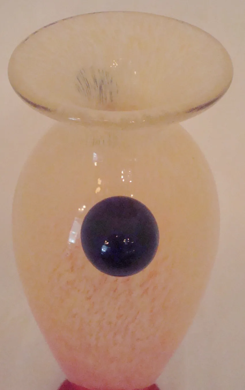 Verre signé Schneider avec design décoratif aux tons doux, fond minimaliste.