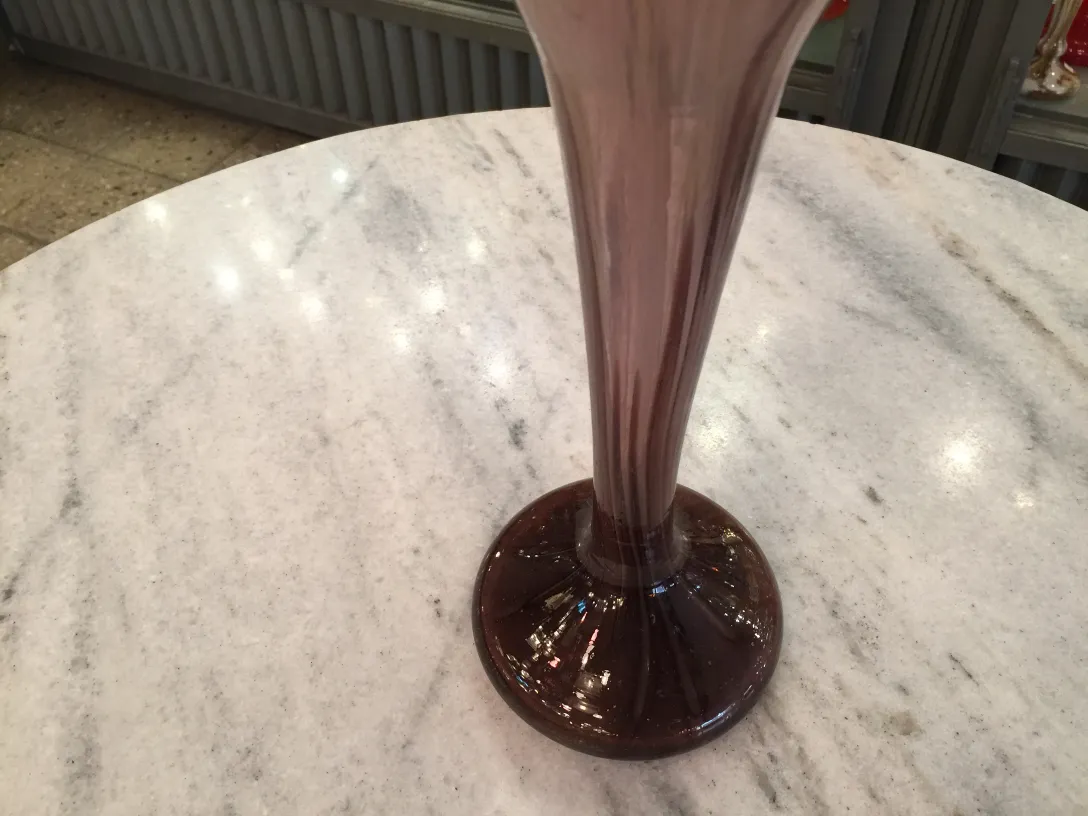 Antique signed glass Schneider in purple on a pedestal, cream background.