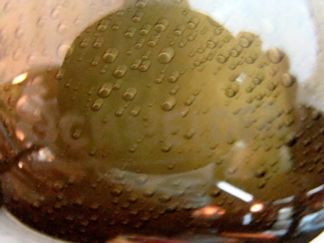 Vetro antico firmato Schneider, con bolle visibili.