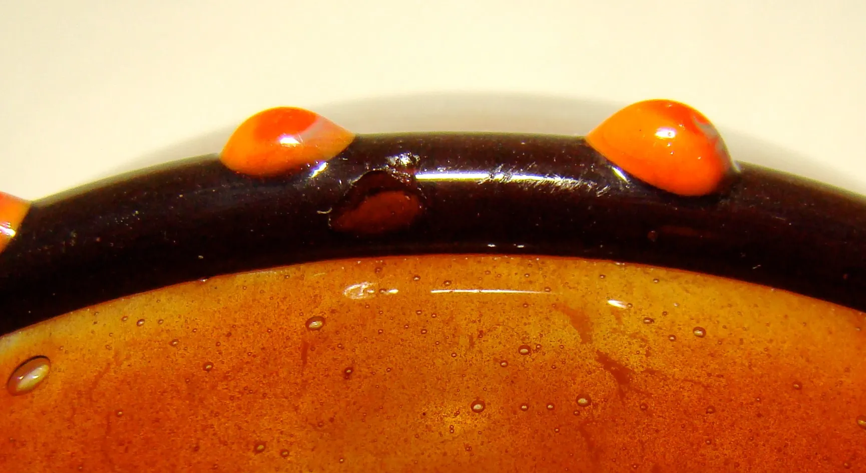 Antikes signiertes Glas von Schneider mit orangefarbenen und schwarzen Details, klassische Atmosphäre.