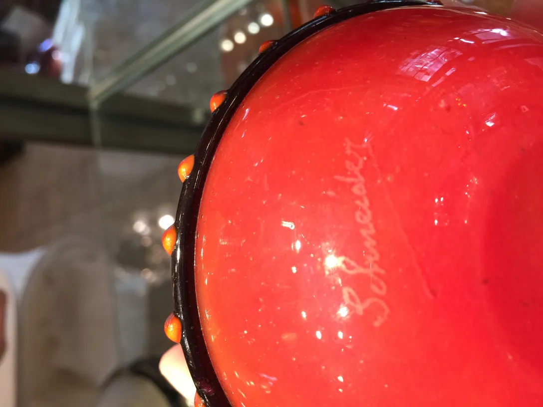 Detail eines antiken Glases mit der Signatur von Schneider, lebendige Farben.