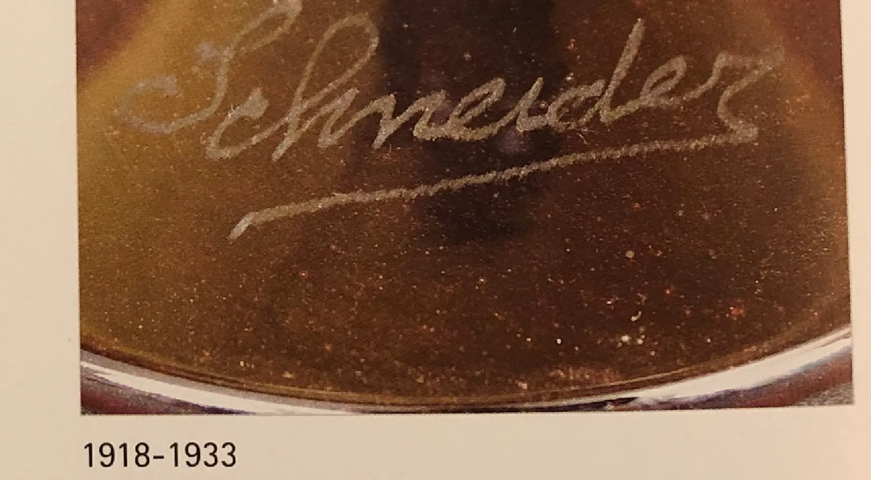 antique glass with Schneider's signature in French, decorative background