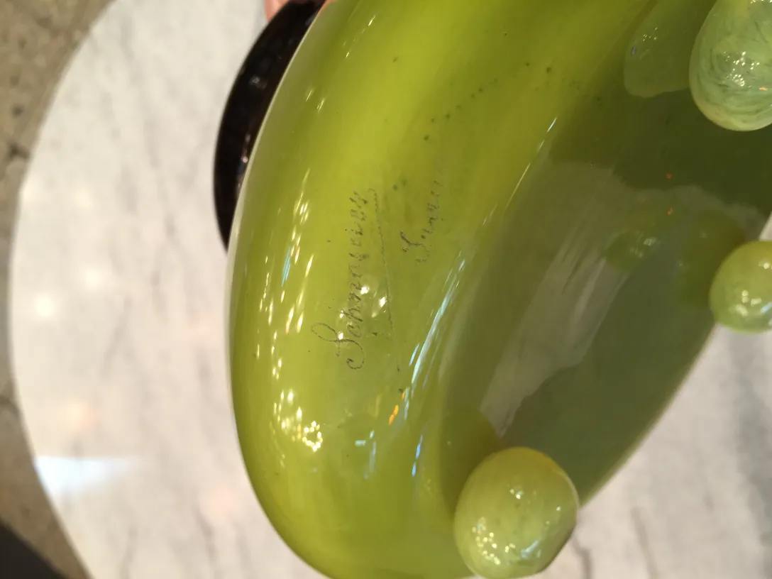 Signiertes Glas Schneider mit grüner Signaturdetails.