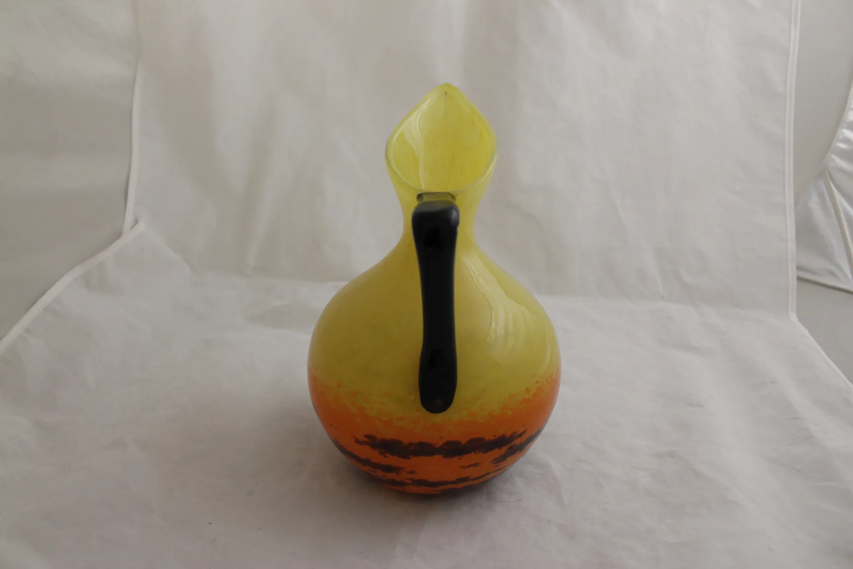pitcher of signed glass in yellow with dark accents