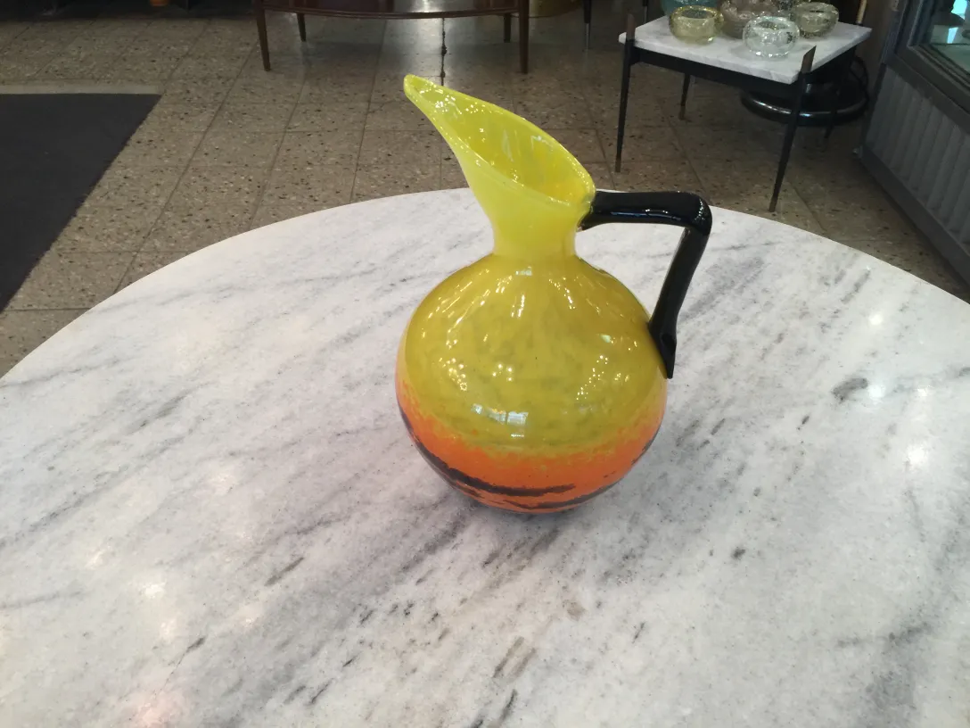 Brocca colorata in vetro firmato Schneider su un tavolo