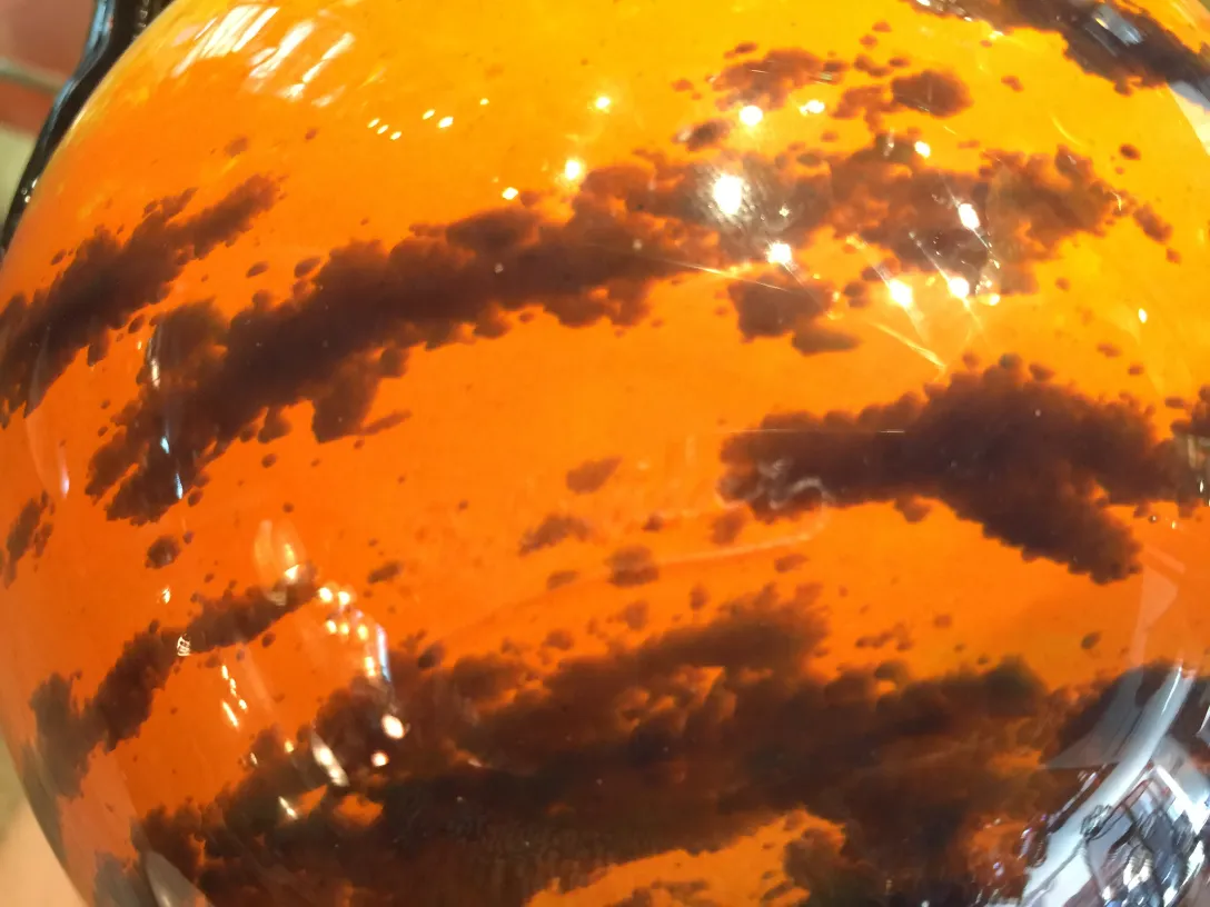 Verre ancien avec motifs orange et noir.