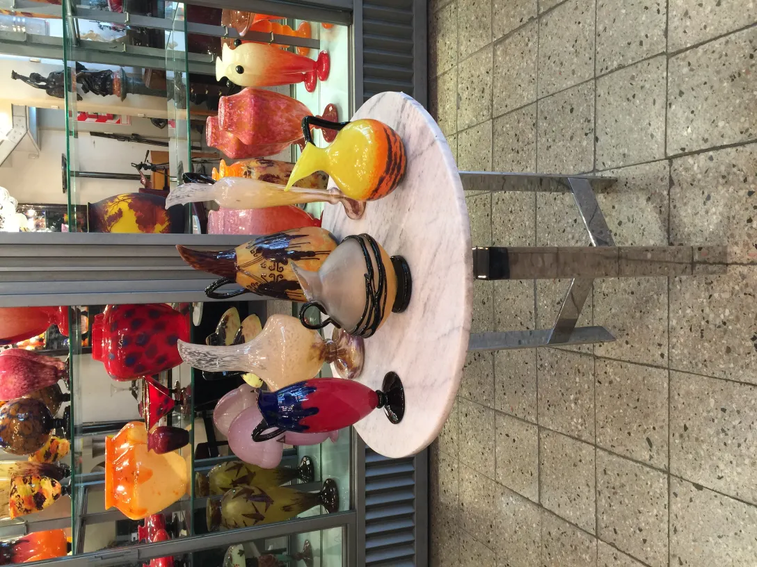 Signiertes Glas von Schneider in verschiedenen Farben und Formen, präsentiert in einem antiken Umfeld.