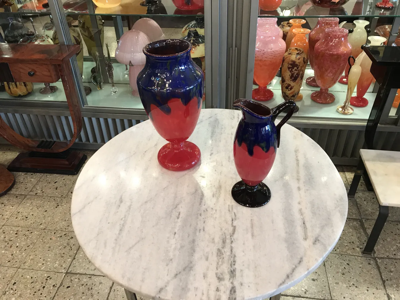 vase et pichet en verre signé schneider avec des couleurs vives sur une table en marbre