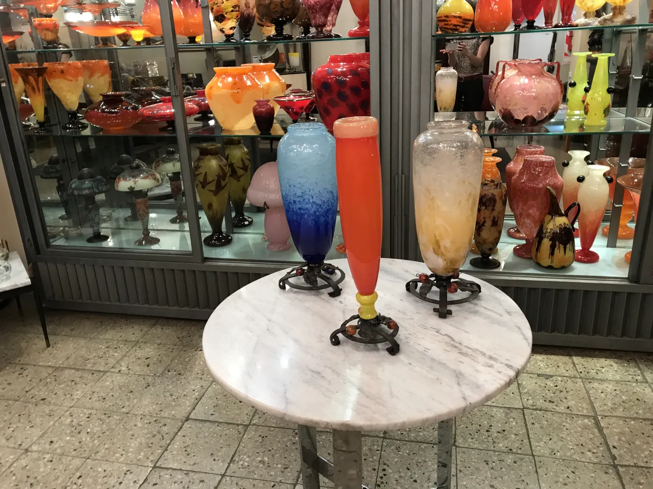 서명된 유리잔(Schneider)가 고대 캐비닛에서 생생한 색상으로 전시되고 있습니다.