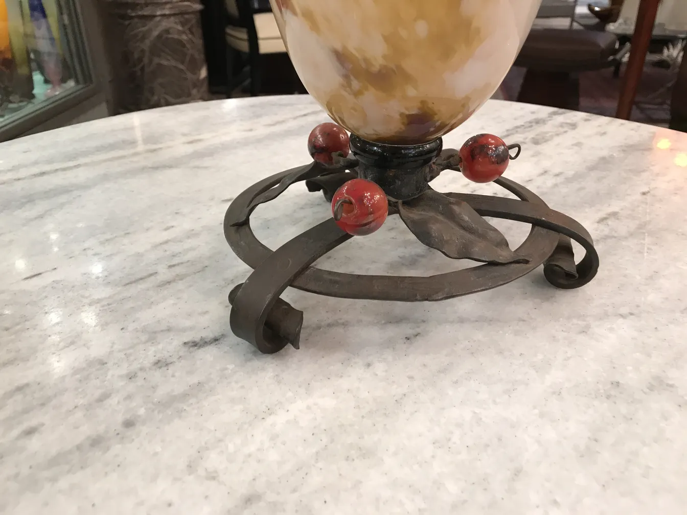 Base de metal con vidrio decorativo y detalles rojos.