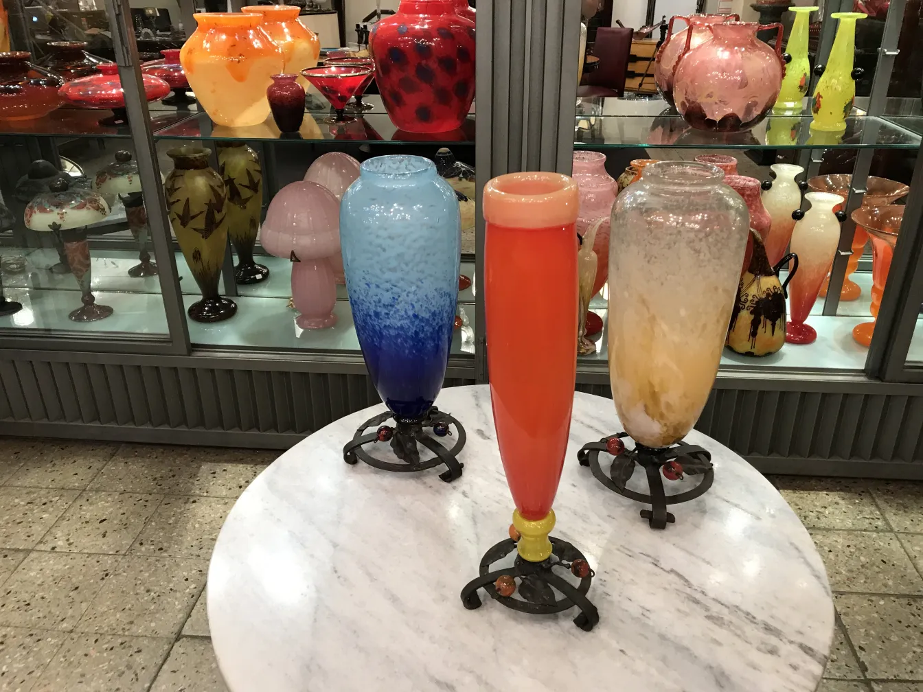 drei bunte Glasvasen, eine blaue, eine orange und eine mit weißen Details