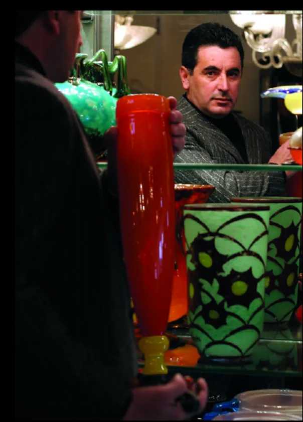 Vetro firmato Schneider in tonalità colorate, tenuto da una persona.