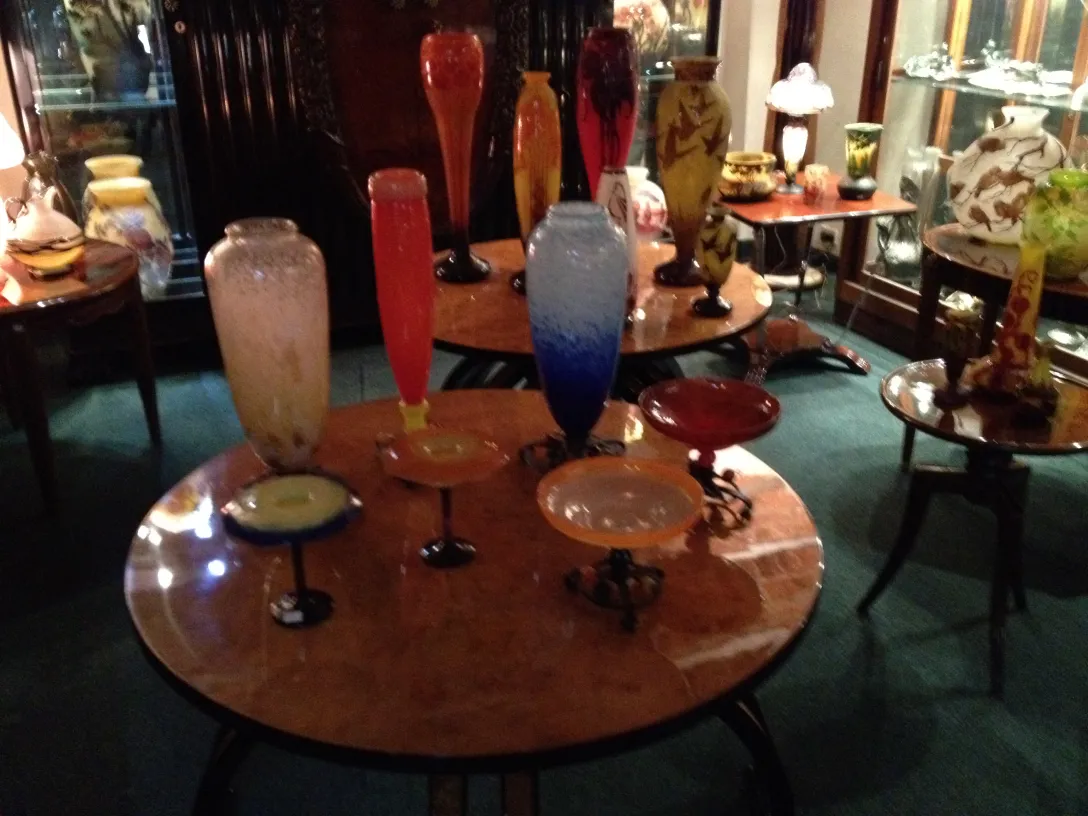 Ensemble de verre signé par Schneider dans un cadre ancien, avec des couleurs vives dans des vases.