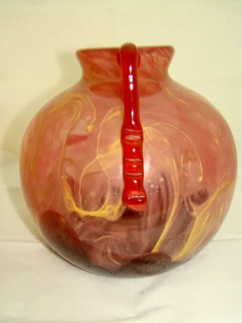 Glaskanne mit roten und gelben Mustern.