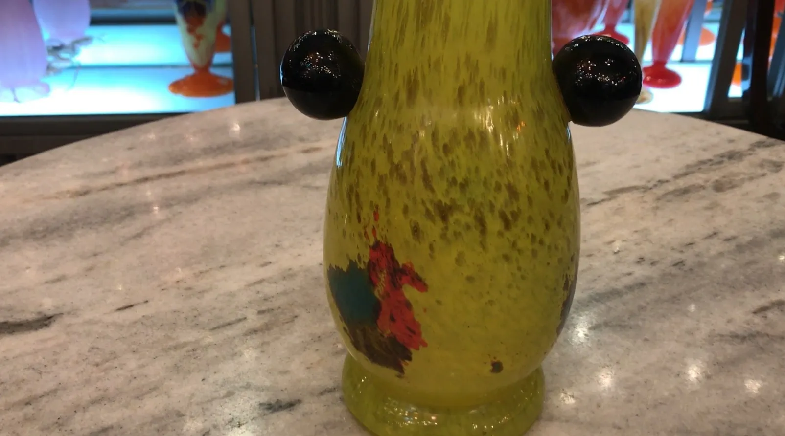 Vue latérale d'un verre signé de Schneider avec des détails colorés sur un fond lumineux