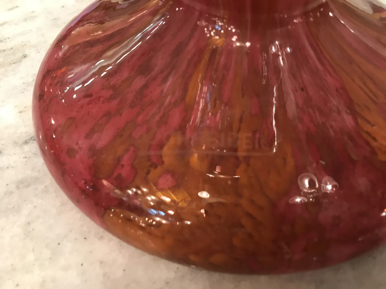 Vidro antigo com assinatura de Schneider em vermelho e marrom.