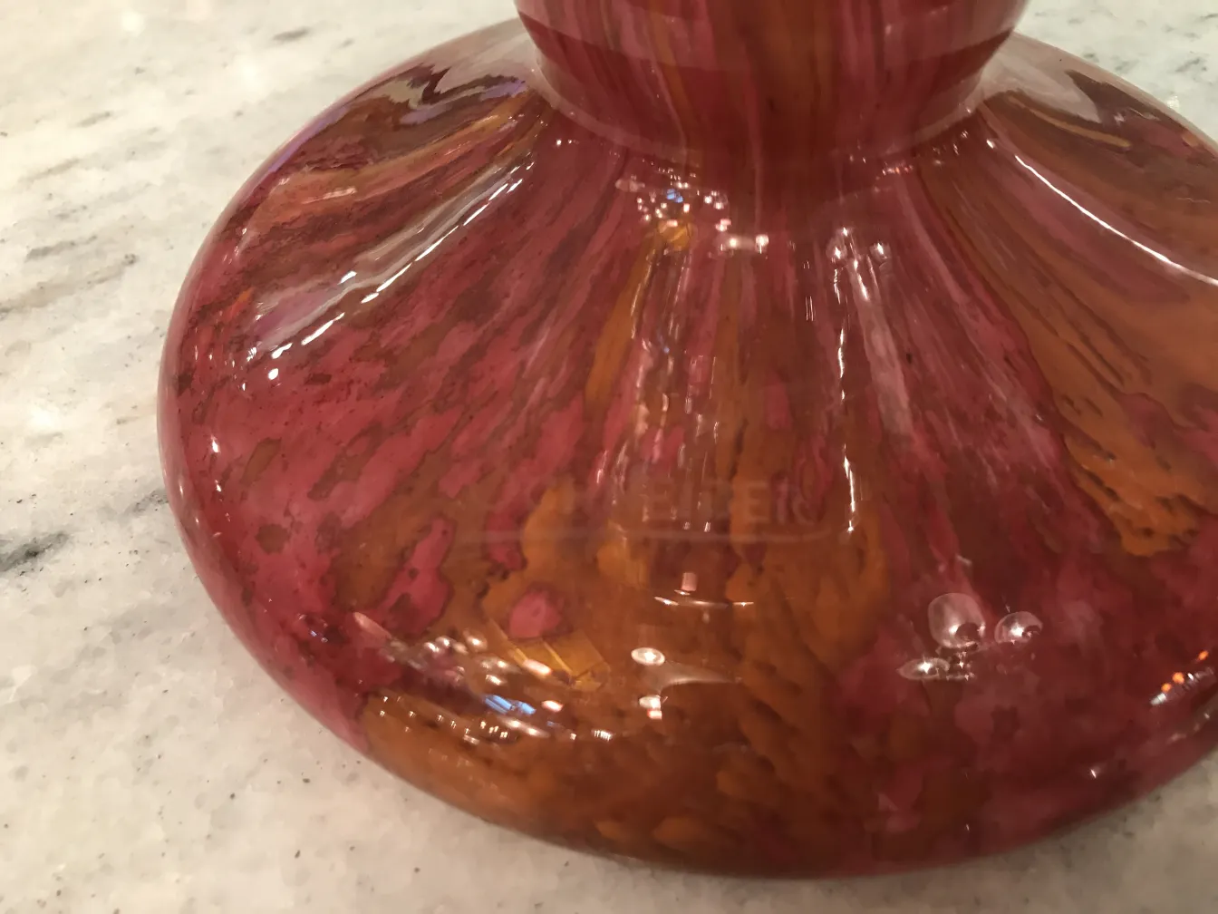 Vidrio antiguo firmado por Schneider, color rosa y marrón, con entorno decorativo.