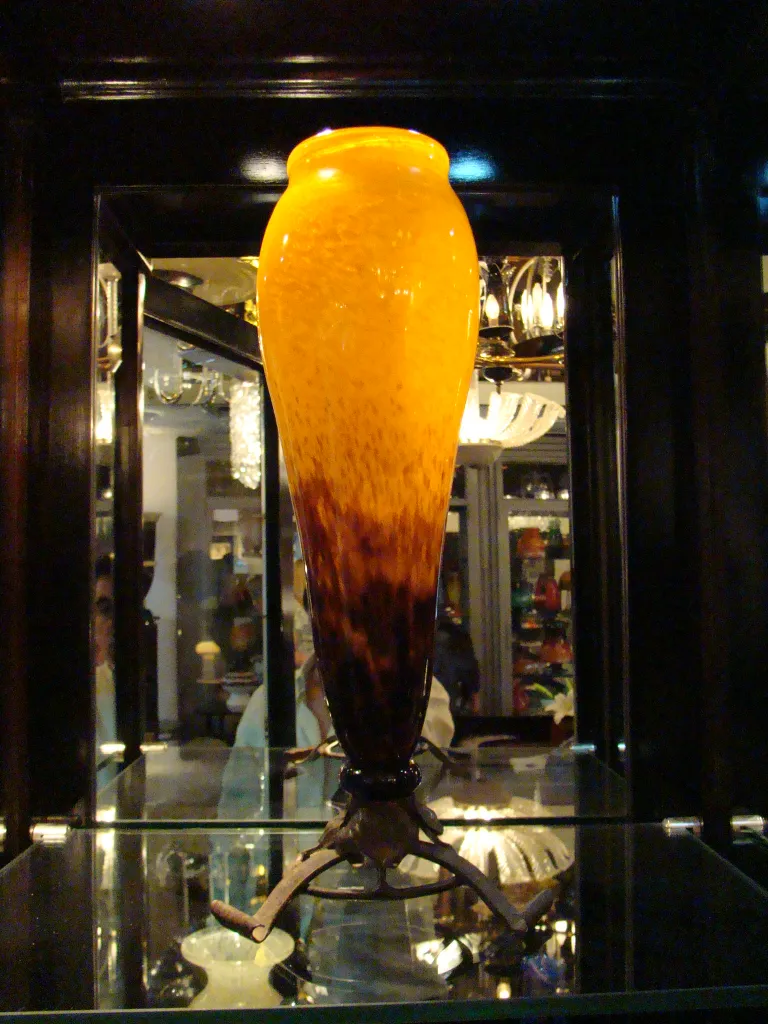 jarrón antigüedad, con color ámbar y detalles oscuros en la base.