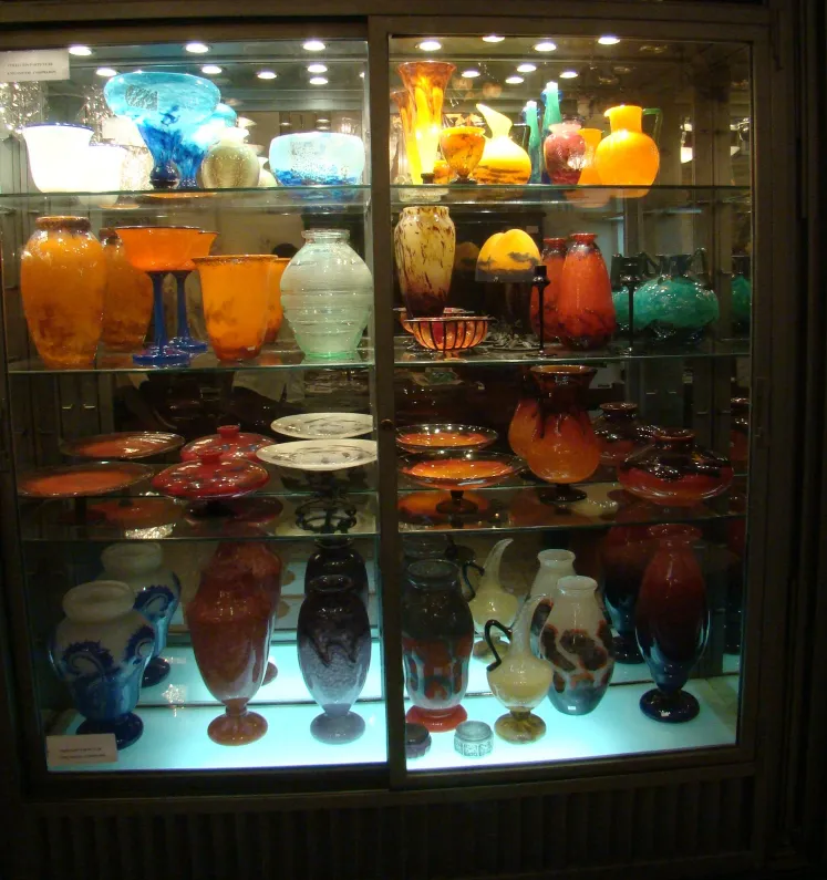 Collection de verres anciens, y compris ceux signés Schneider, diverses formes et couleurs.