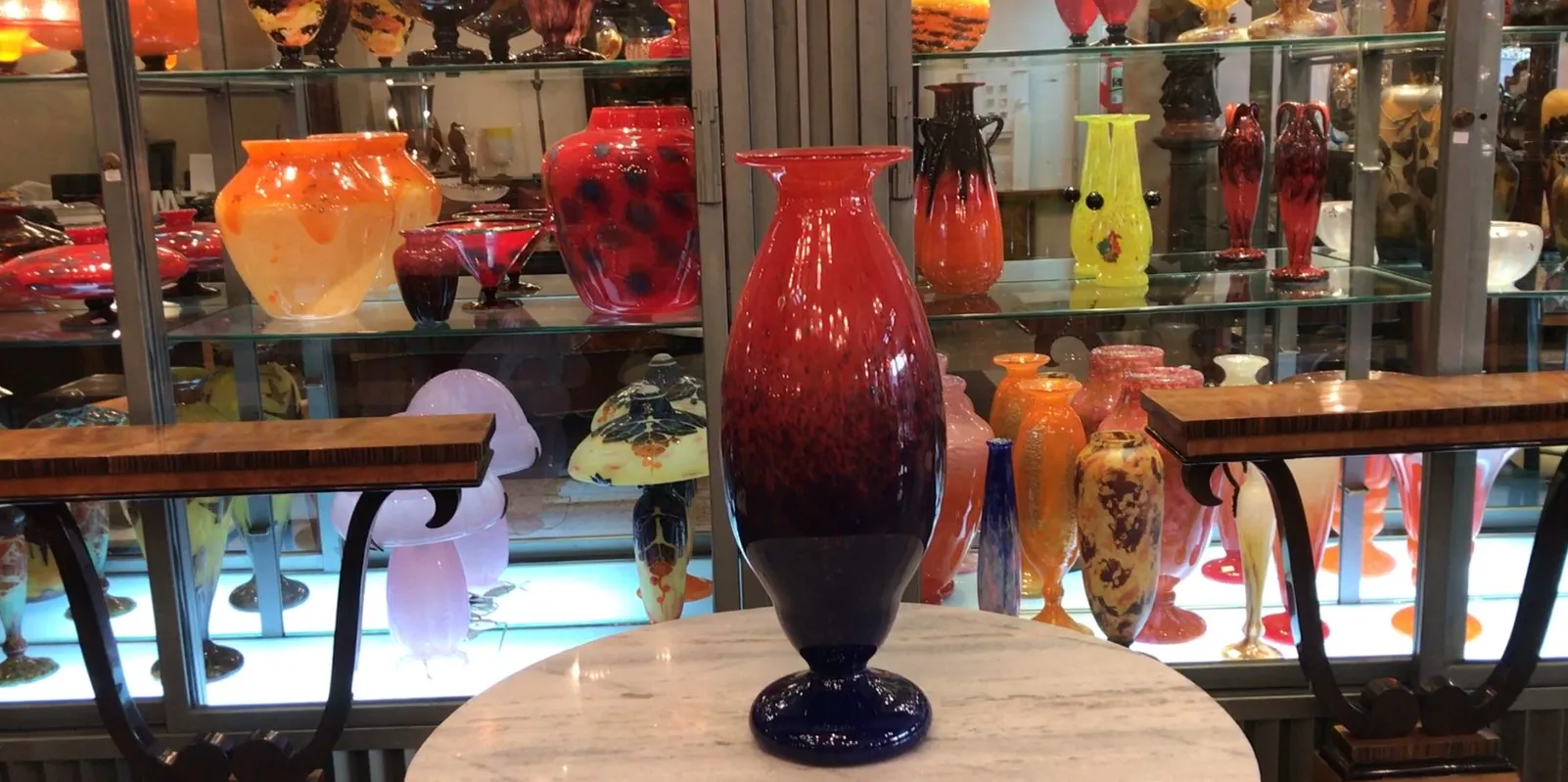 signiertes glasvasen in einem antiquitätenumfeld