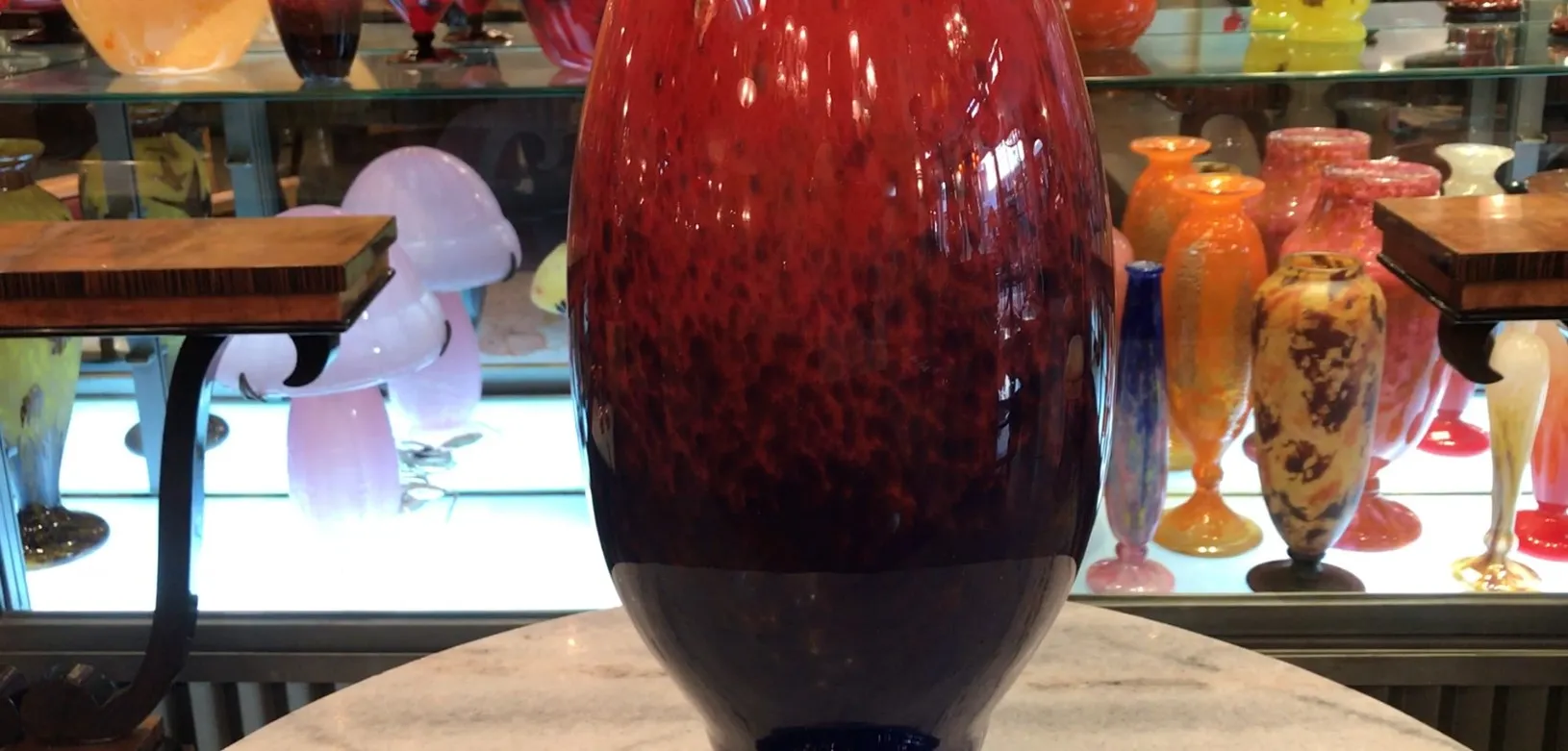 Vase en verre signé par Schneider, rouge et bleu, exposé.
