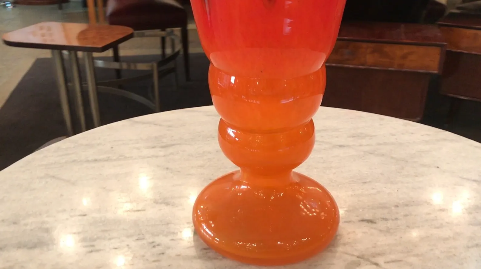 signiertes glas von schneider mit buntem design in gemütlicher umgebung