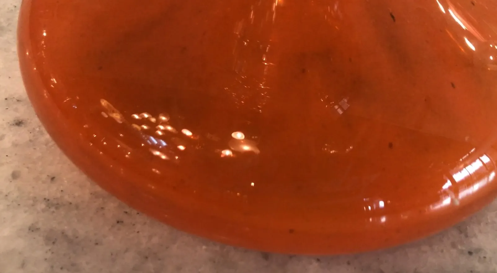 Détails d'un verre ancien signé, couleurs vives et forme décorative.