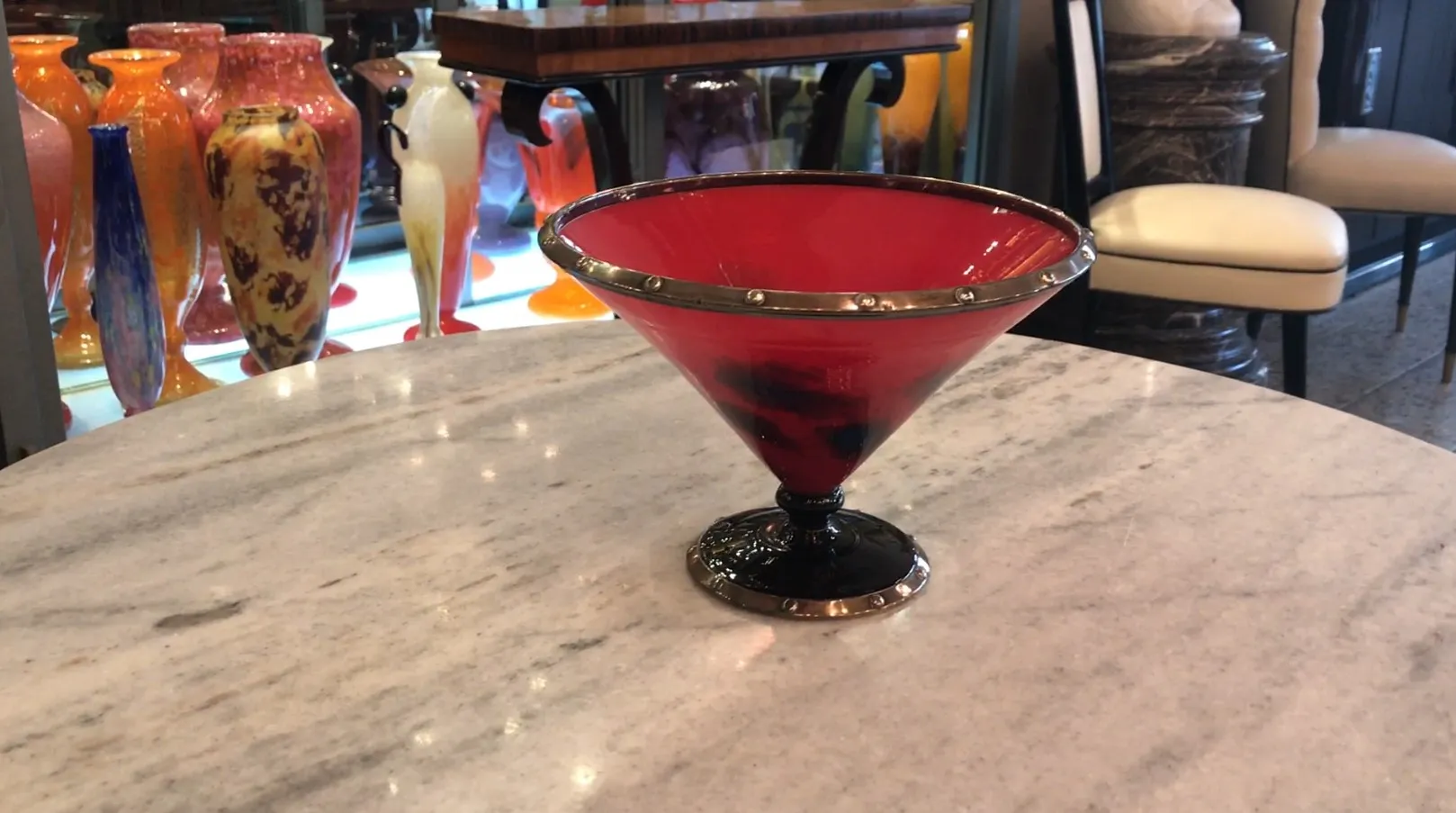 vista de um elegante vidro vermelho com base preta e detalhes prateados